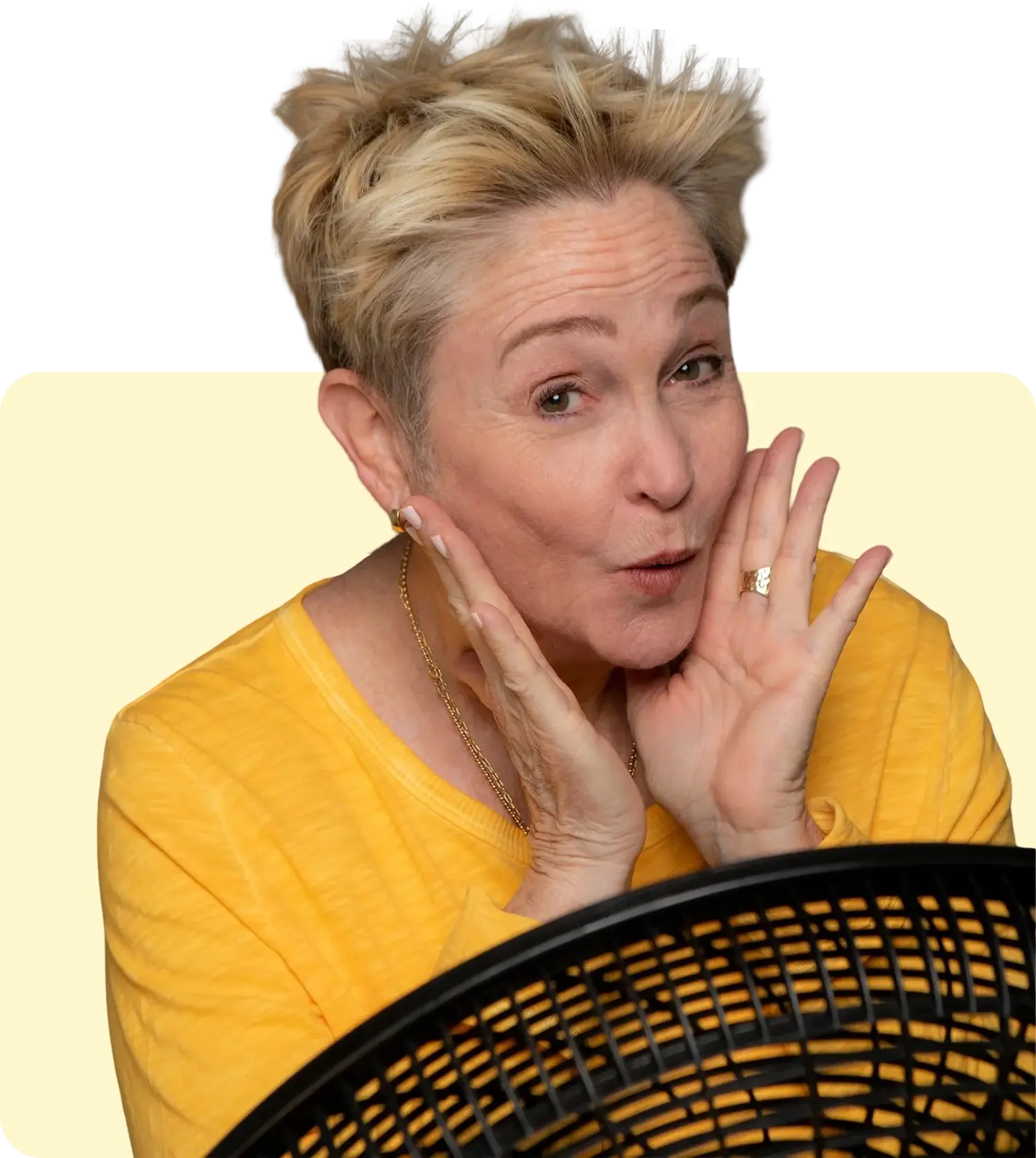 Person in yellow shirt posing near fan.
